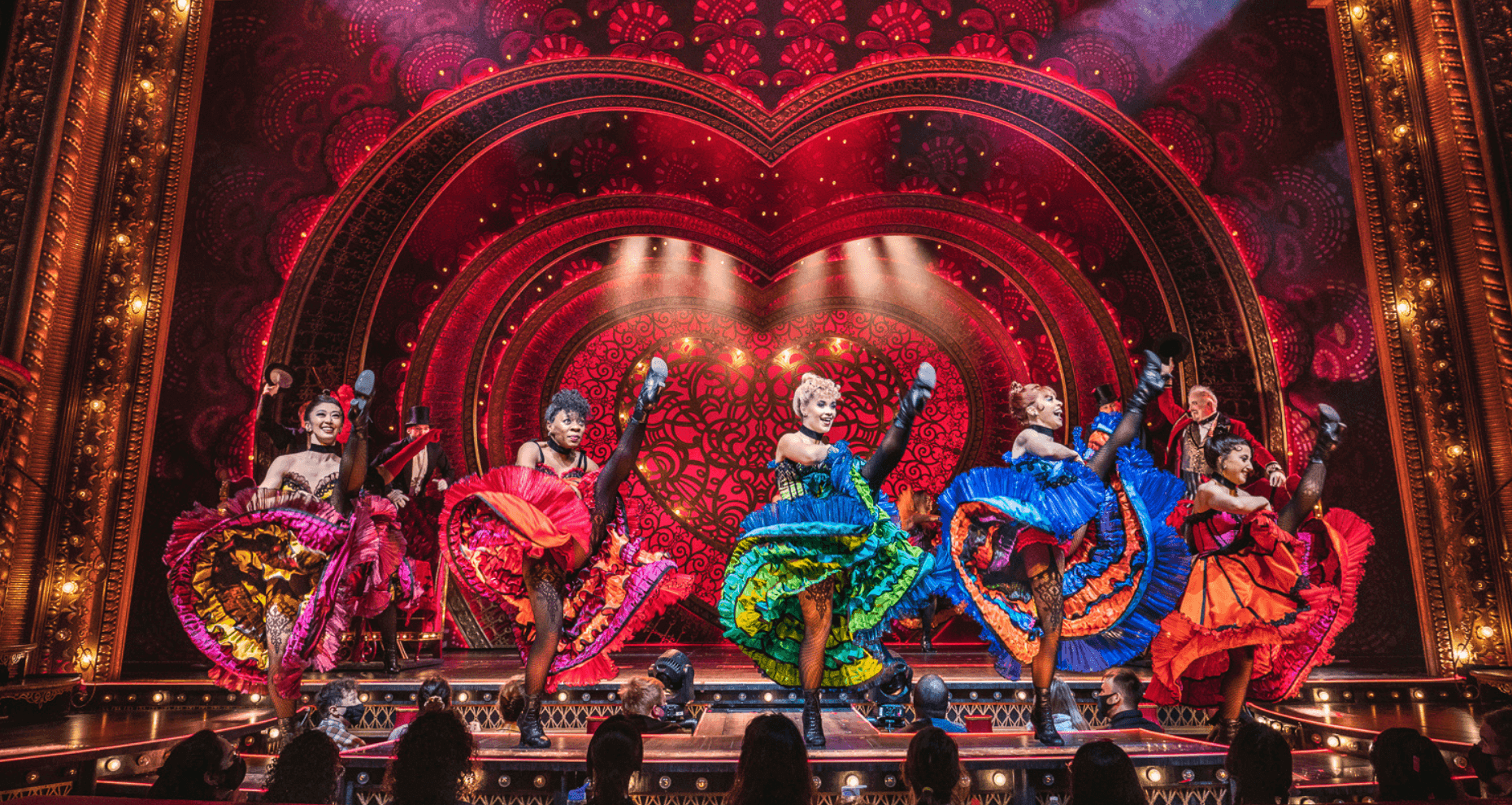 Colorful can-can dancers on heart-decorated stage